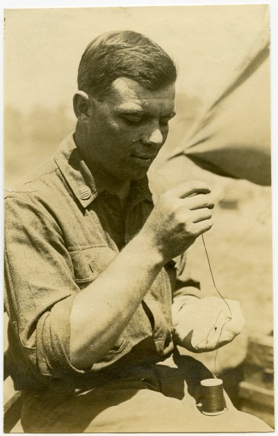 Soldier Using a Needle and Thread to Repair a Sock by Carl Michel